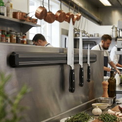 magnetic knife holder in restaurant holding some knives